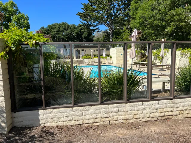 a backyard of a house with potted plants and palm trees