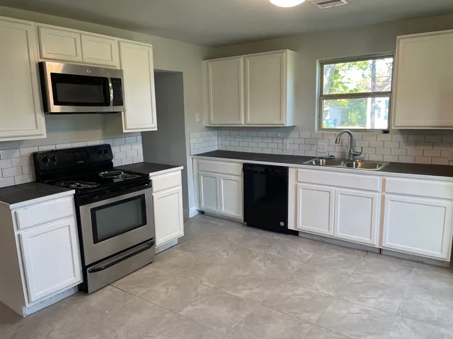 a kitchen with a sink stove and microwave