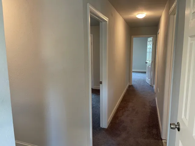a view of a hallway with a wooden door