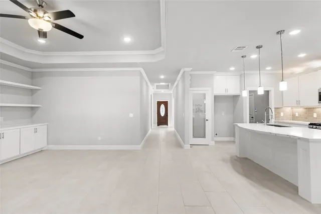 a view of an empty room and kitchen view