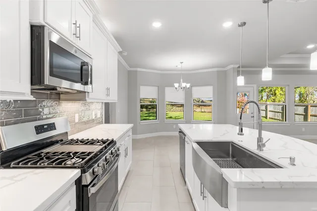 a kitchen with stainless steel appliances a sink a stove and microwave