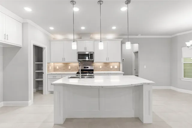 a large kitchen with kitchen island a sink stainless steel appliances and window