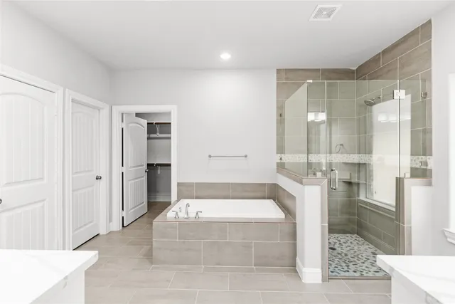 a spacious bathroom with a tub shower and mirror