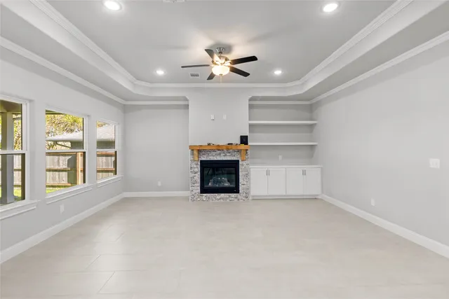 a view of an empty room with a fireplace and a window