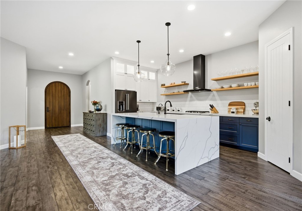 42339 Casa Verde Temecula, CA 92592 - Photo 10 of 59 a open kitchen with stainless steel appliances granite countertop a stove top oven a sink dishwasher and white cabinets with wooden floor