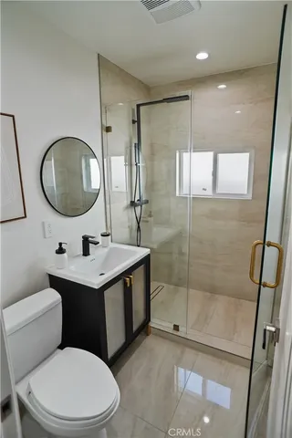 a bathroom with a toilet a sink a mirror and vanity