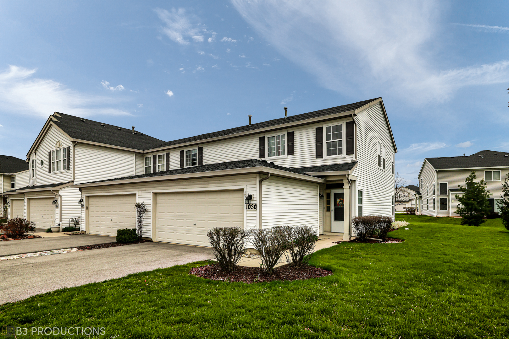 a front view of a house with a garden and plants