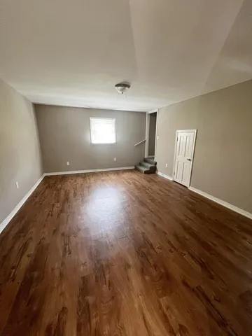 a view of a room with wooden floor and window