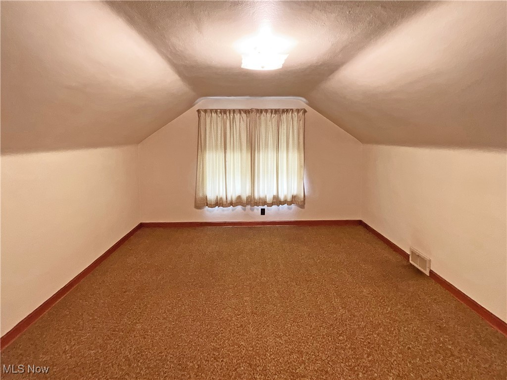 63 Mc Coll Road Colliers, WV 26035 - Photo 11 of 17 Bonus room featuring carpet, a textured ceiling, and vaulted ceiling