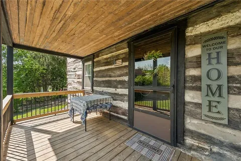 a balcony with wooden floor table and chairs