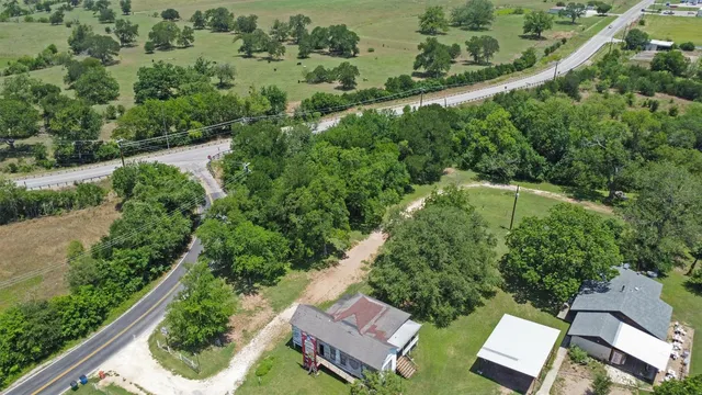 an aerial view of a residential houses with outdoor space and street view