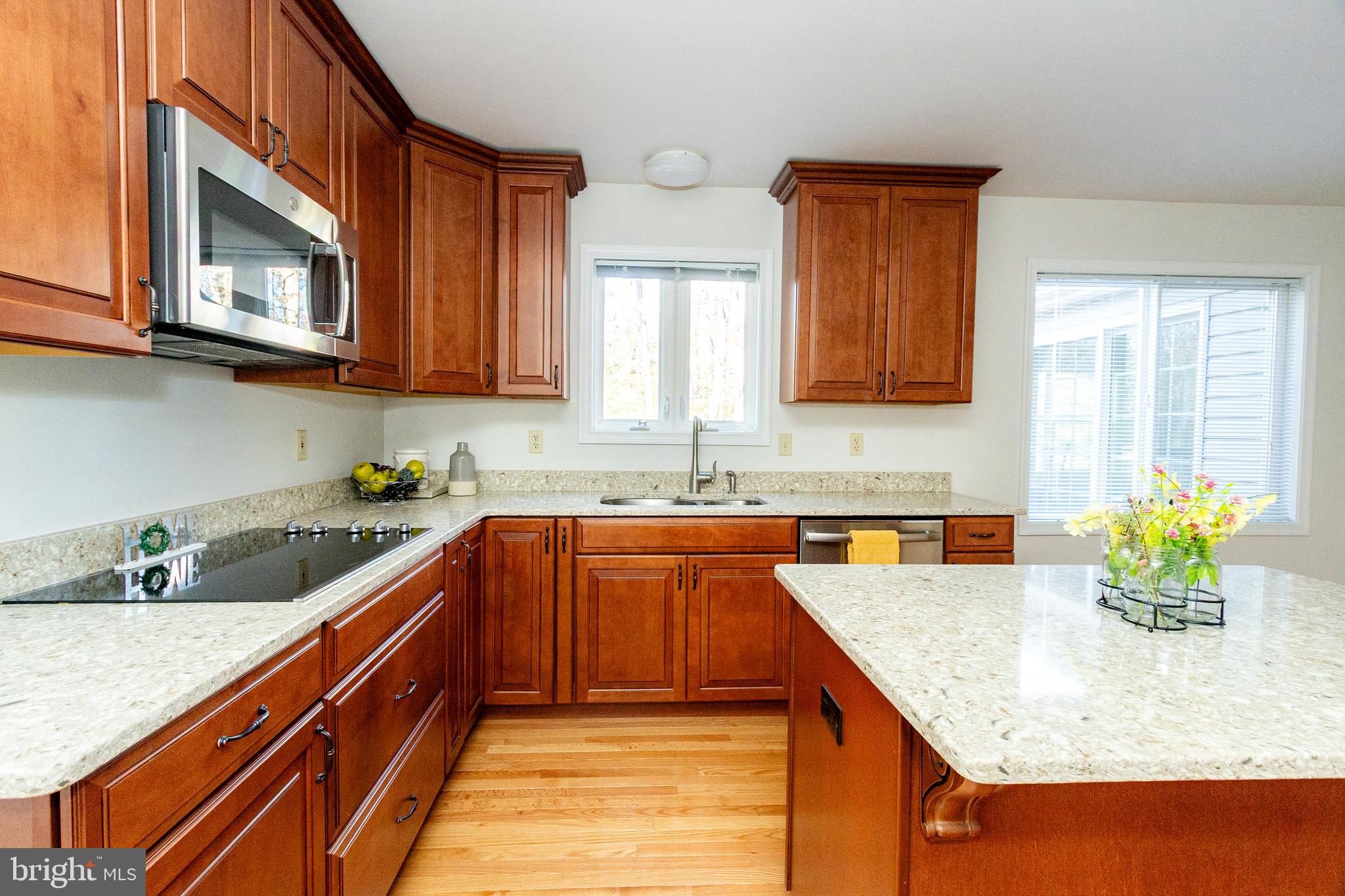 20753 Chestnut Ridge Drive Leonardtown, MD 20650 - Photo 14 of 45 a kitchen with stainless steel appliances granite countertop a sink a microwave counter space and cabinets