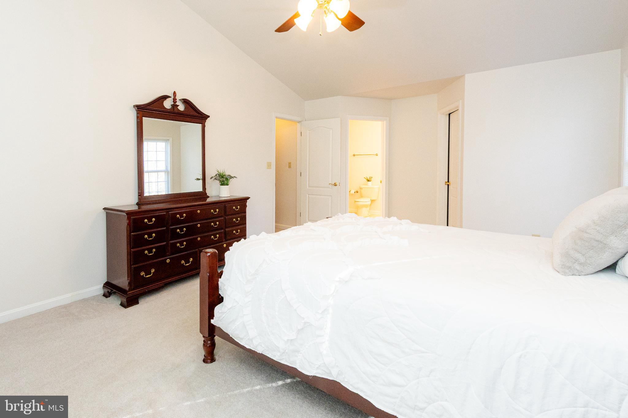 20753 Chestnut Ridge Drive Leonardtown, MD 20650 - Photo 26 of 45 a bedroom with a bed and dresser with mirror