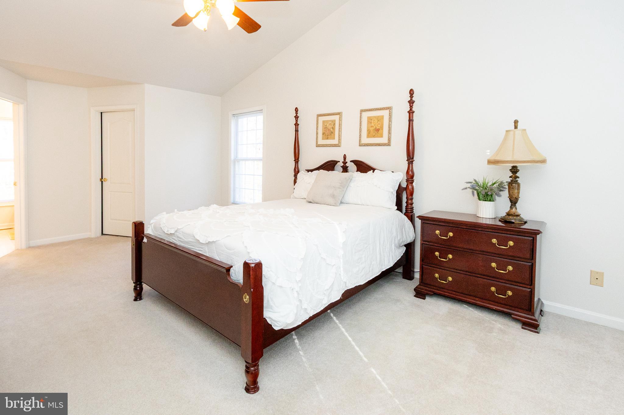 20753 Chestnut Ridge Drive Leonardtown, MD 20650 - Photo 27 of 45 a bedroom with a bed and a lamp on dresser