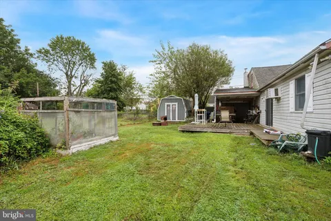 a view of a chair and table in backyard of the house