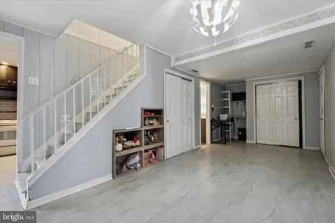 a view of empty room with stairs and white walls