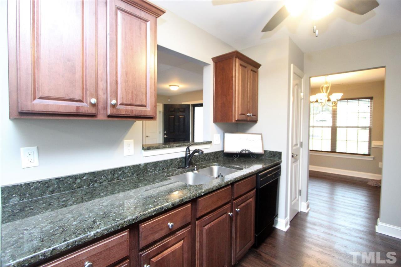 203 Orkney Road Stem, NC 27581 - Photo 11 of 30 a kitchen with granite countertop a sink and a wooden cabinets