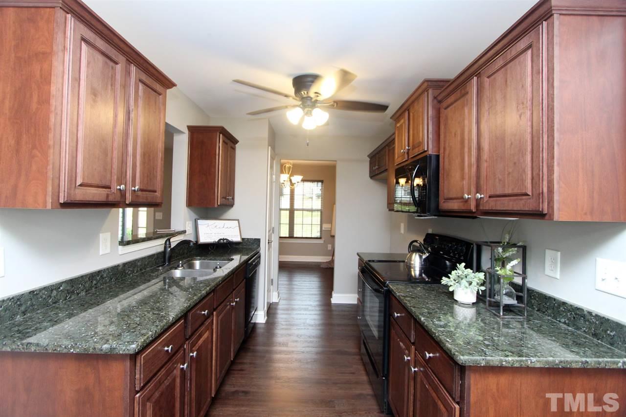203 Orkney Road Stem, NC 27581 - Photo 10 of 30 a kitchen with granite countertop stainless steel appliances a sink dishwasher refrigerator stove and cabinets