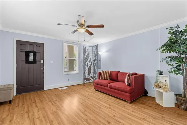 a living room with furniture and a ceiling fan