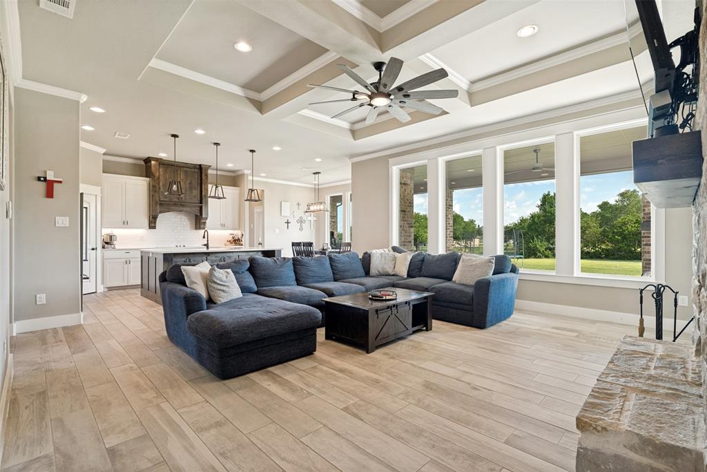 6913 Veal Station Road Weatherford, TX 76085 - Photo 5 of 31 Open-concept living area featuring light wood-finish flooring and a coffered ceiling with a ceiling fan