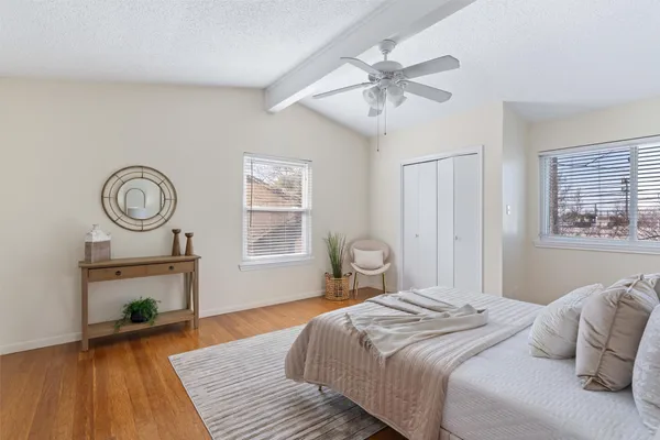 a bedroom with a large bed and a wooden floor