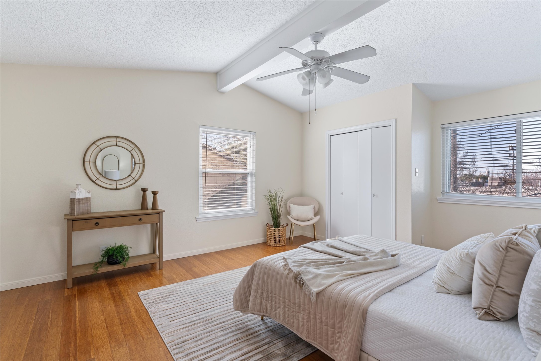 11902 Barrington Way Austin, TX 78759 - Photo 13 of 30 Primary bedroom featuring a textured ceiling, beam ceiling, wood finished floors, ceiling fan, and a closet