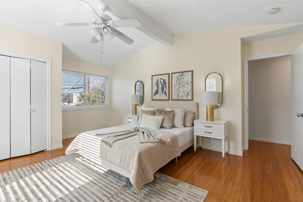 a bedroom with a bed a chandelier and dresser
