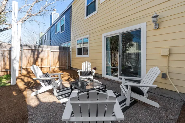 a view of backyard with large trees and a wooden fence