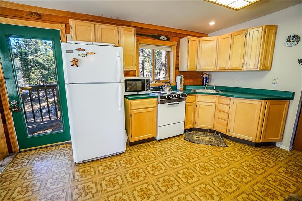 1276 South Crystal Road Lake George, CO 80827 - Photo 8 of 25 a kitchen with a refrigerator a stove top oven a sink and a window