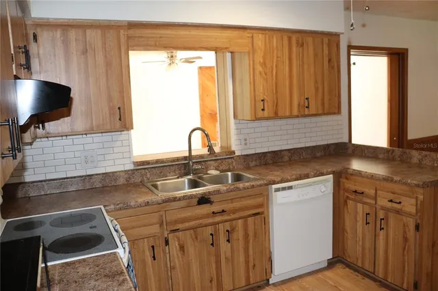 a kitchen with a sink cabinets and a window