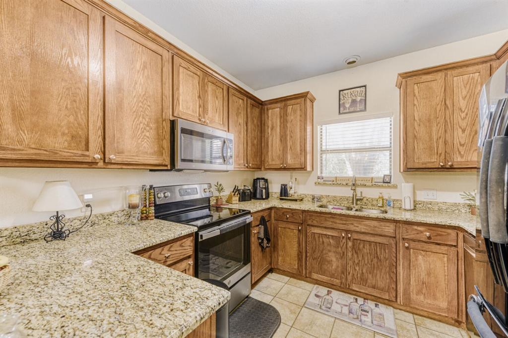 6525 Greenway Road Fort Worth, TX 76116 - Photo 20 of 29 a kitchen with stainless steel appliances granite countertop a sink stove and microwave