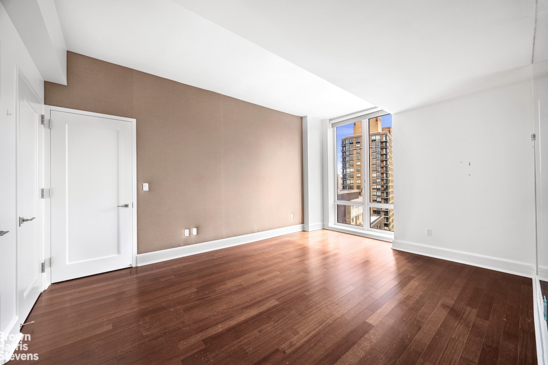 60 Riverside Boulevard, Unit 3004 Manhattan, NY 10069 - Photo 14 of 32 a view of an empty room with wooden floor and a window