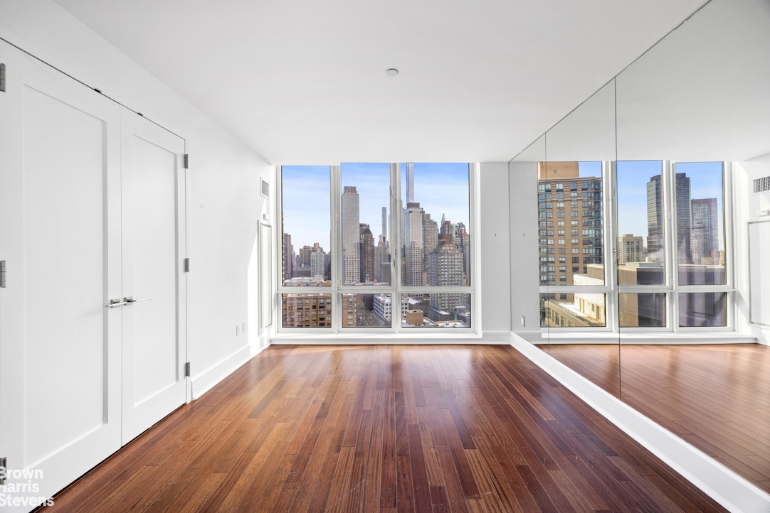 60 Riverside Boulevard, Unit 3004 Manhattan, NY 10069 - Photo 18 of 32 a large white room with a large window and wooden floor