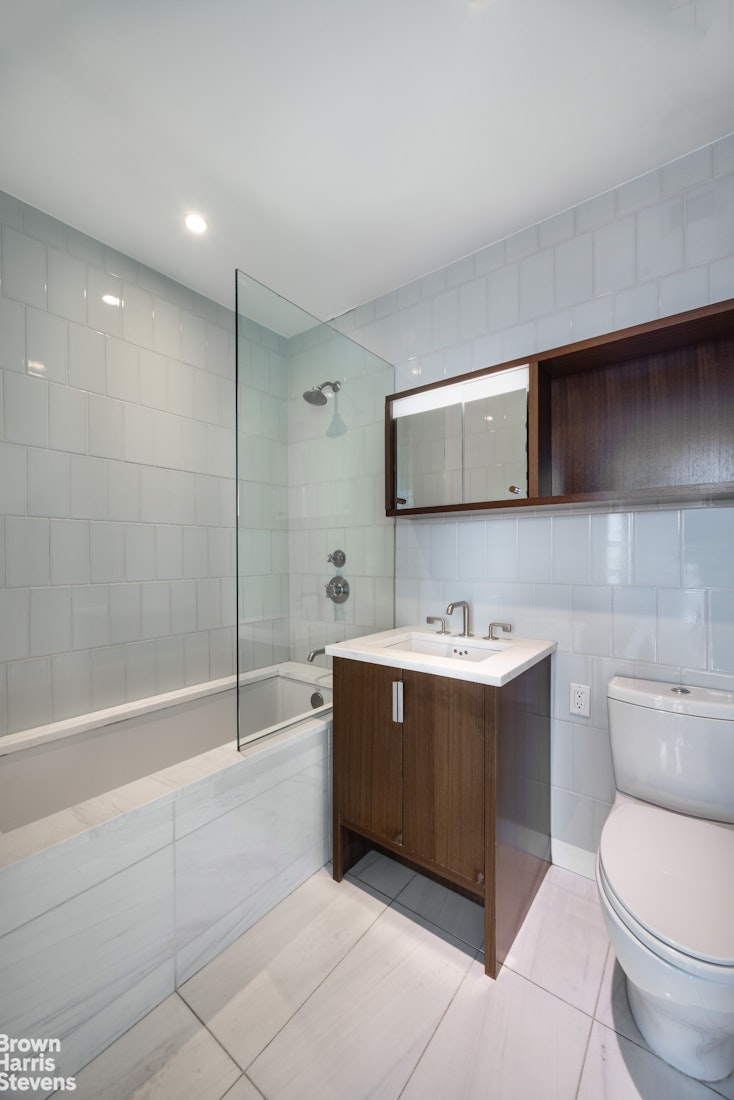 60 Riverside Boulevard, Unit 3004 Manhattan, NY 10069 - Photo 19 of 32 a bathroom with a bathtub sink mirror and toilet