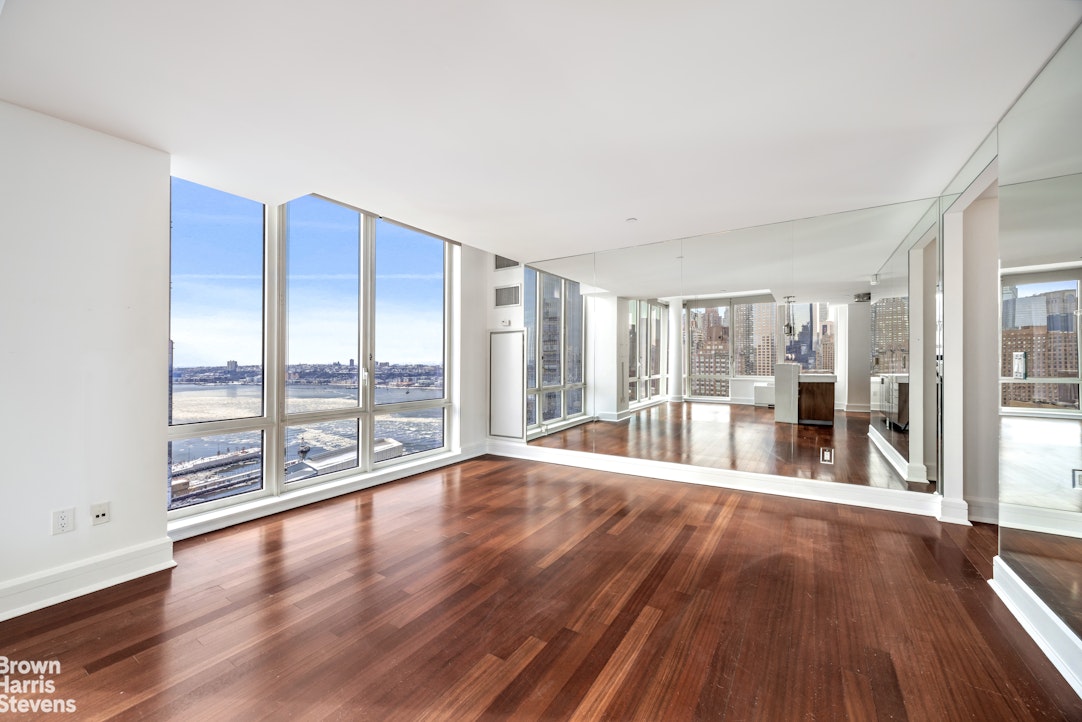60 Riverside Boulevard, Unit 3004 Manhattan, NY 10069 - Photo 2 of 32 a big room with wooden floor and windows