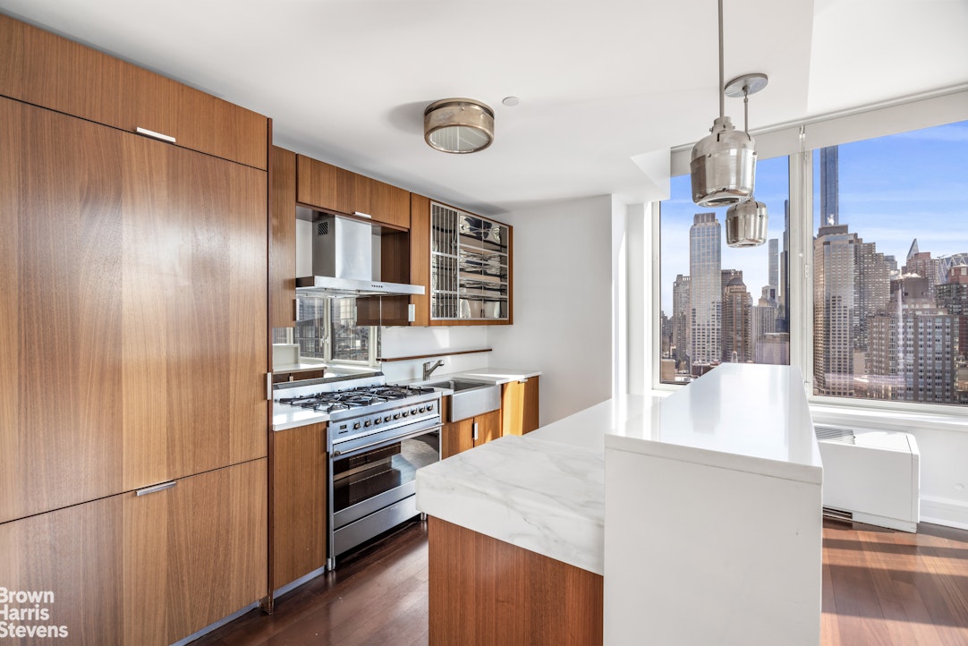 60 Riverside Boulevard, Unit 3004 Manhattan, NY 10069 - Photo 7 of 32 a kitchen with a stove a refrigerator and a view of living room