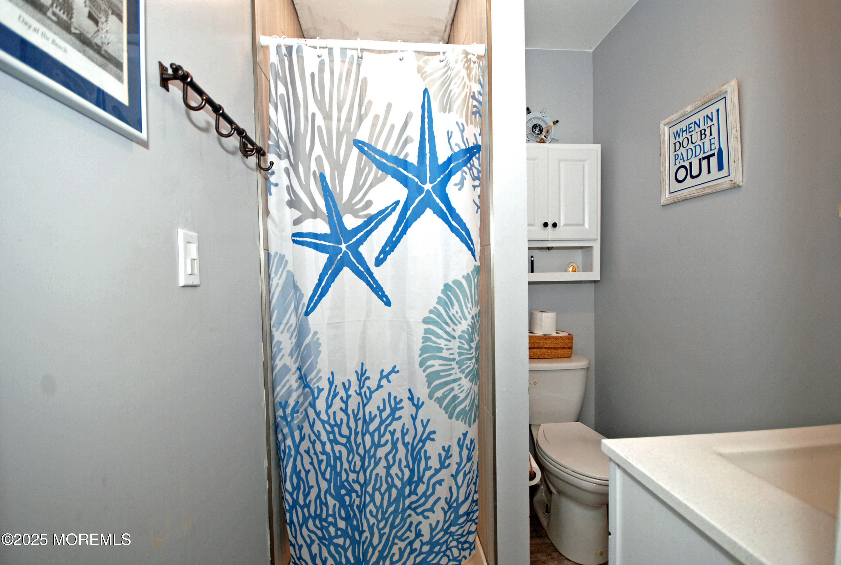 25 Beach Boulevard Highlands, NJ 07732 - Photo 18 of 32 a bathroom with a toilet and a shower curtain
