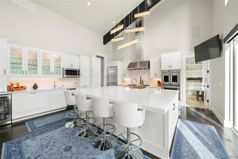 a large white kitchen with a large window