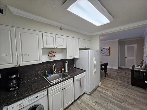 a kitchen with stainless steel appliances a sink dishwasher stove refrigerator and cabinets