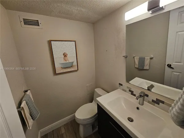 a bathroom with a sink toilet and mirror