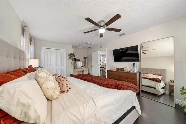 a bedroom with a bed tv and a window