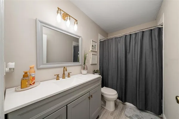 a bathroom with a toilet a sink a vanity and mirror