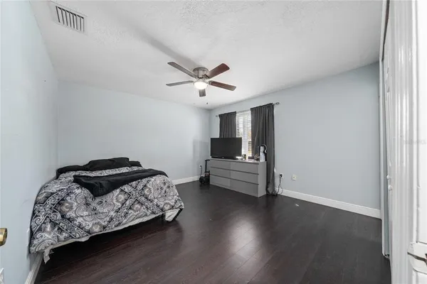 a bedroom with bed and wooden floor