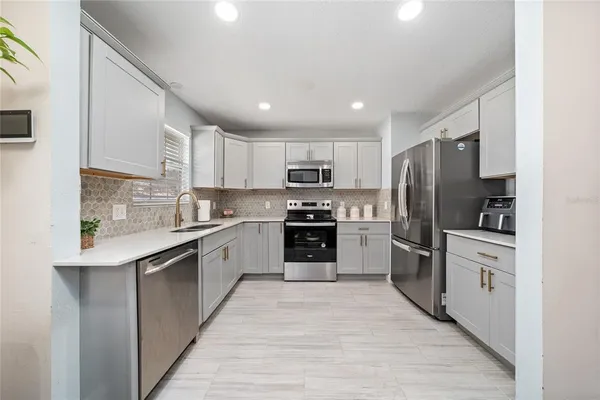 a large kitchen with cabinets stainless steel appliances and a window