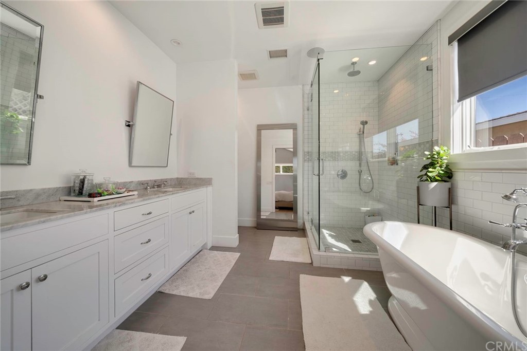 277 Knox Place Costa Mesa, CA 92627 - Photo 18 of 21 a spacious bathroom with a granite countertop tub sink a mirror a shower and vanity