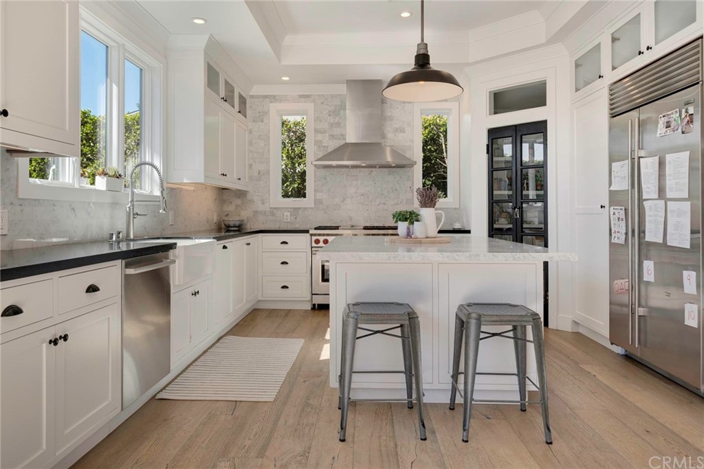 277 Knox Place Costa Mesa, CA 92627 - Photo 6 of 21 a kitchen with stainless steel appliances granite countertop a sink a stove a refrigerator cabinets and dining table