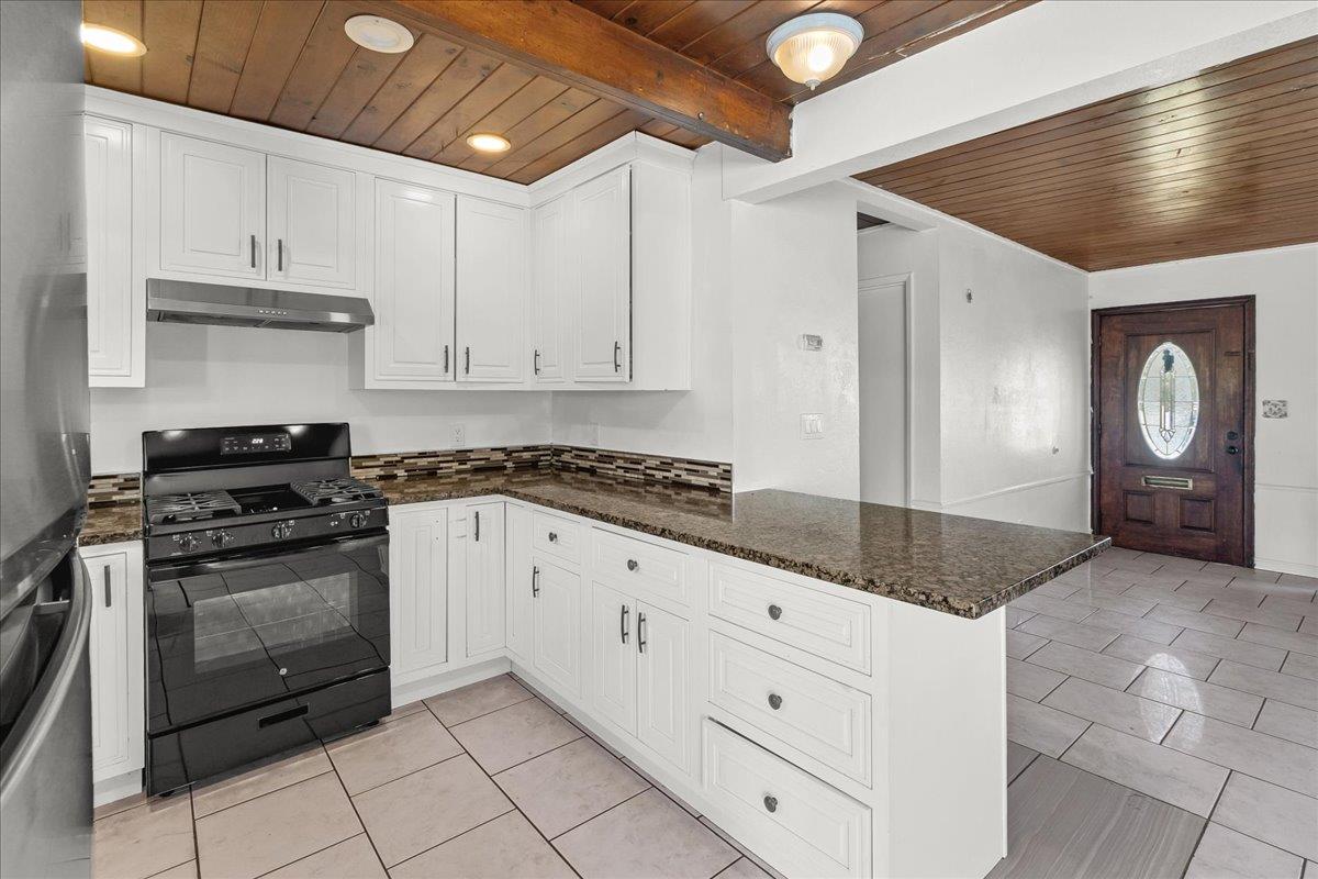 1238 Granada Avenue Salinas, CA 93906 - Photo 15 of 36 a kitchen with granite countertop a stove a sink and cabinets