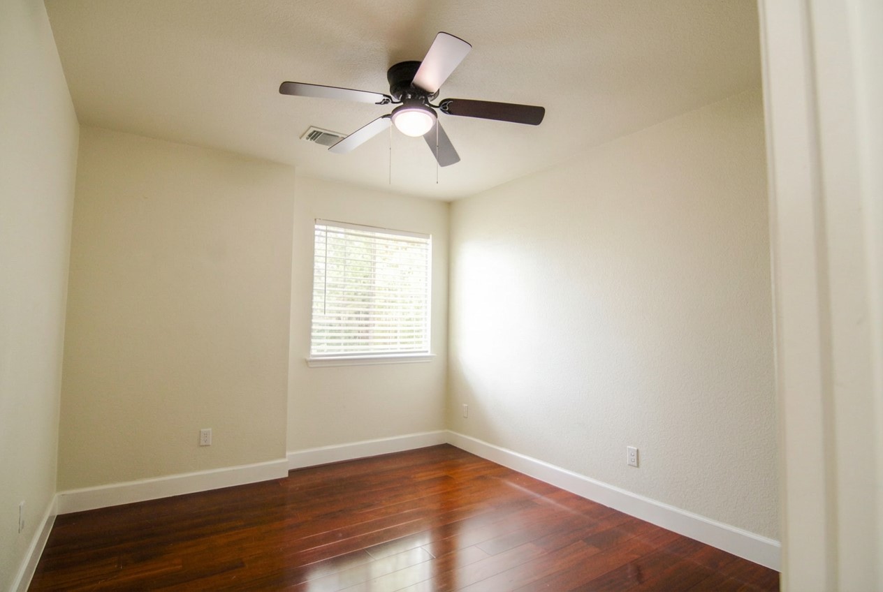 1431 Roxanne's Run Pflugerville, TX 78660 - Photo 16 of 29 Unfurnished room featuring dark wood-style flooring and a ceiling fan