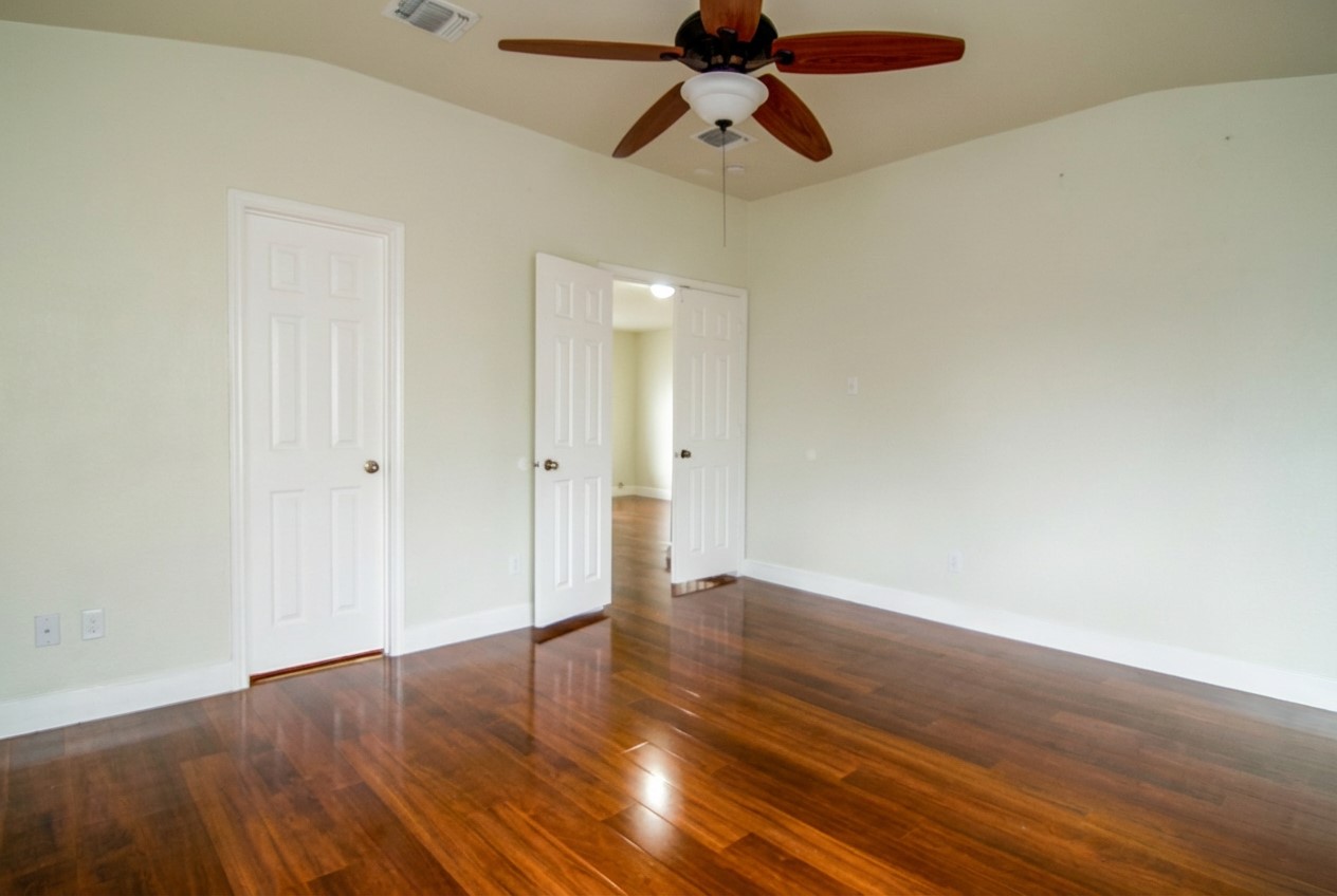 1431 Roxanne's Run Pflugerville, TX 78660 - Photo 20 of 29 Unfurnished room with dark wood-type flooring, a ceiling fan, and lofted ceiling