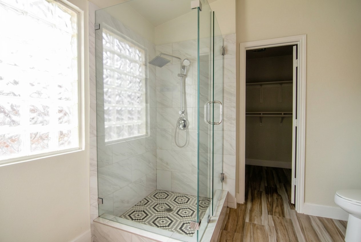 1431 Roxanne's Run Pflugerville, TX 78660 - Photo 22 of 29 Full bathroom featuring a shower stall, a walk in closet, and wood finished floors